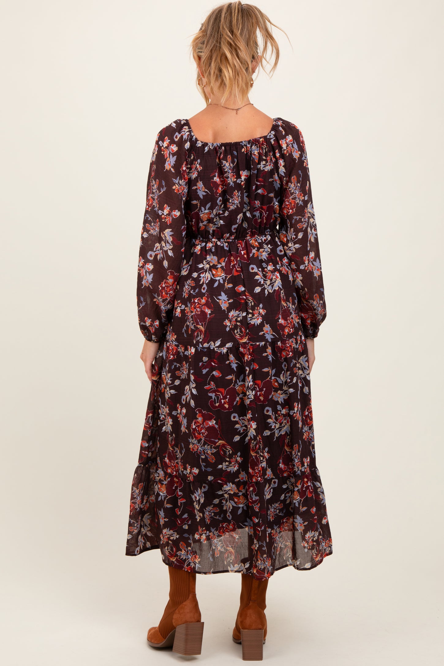 woman wearing a floral black maternity maxi dress with long sleeves, showing the back while standing