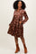 woman wearing a brown velvet floral long sleeve dress with pockets and a tiered skirt, styled with ankle boots