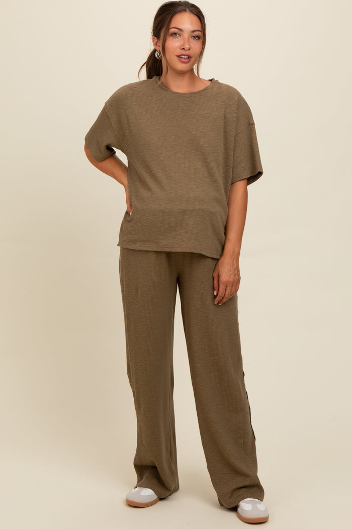 woman wearing a beige ribbed maternity top and matching wide-leg pants, showcasing a relaxed fit