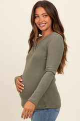 woman wearing an olive green long sleeve ribbed maternity top and showing her baby bump