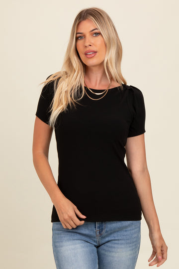woman wearing a black short sleeve top with puff shoulders and a scoop neckline, paired with blue jeans