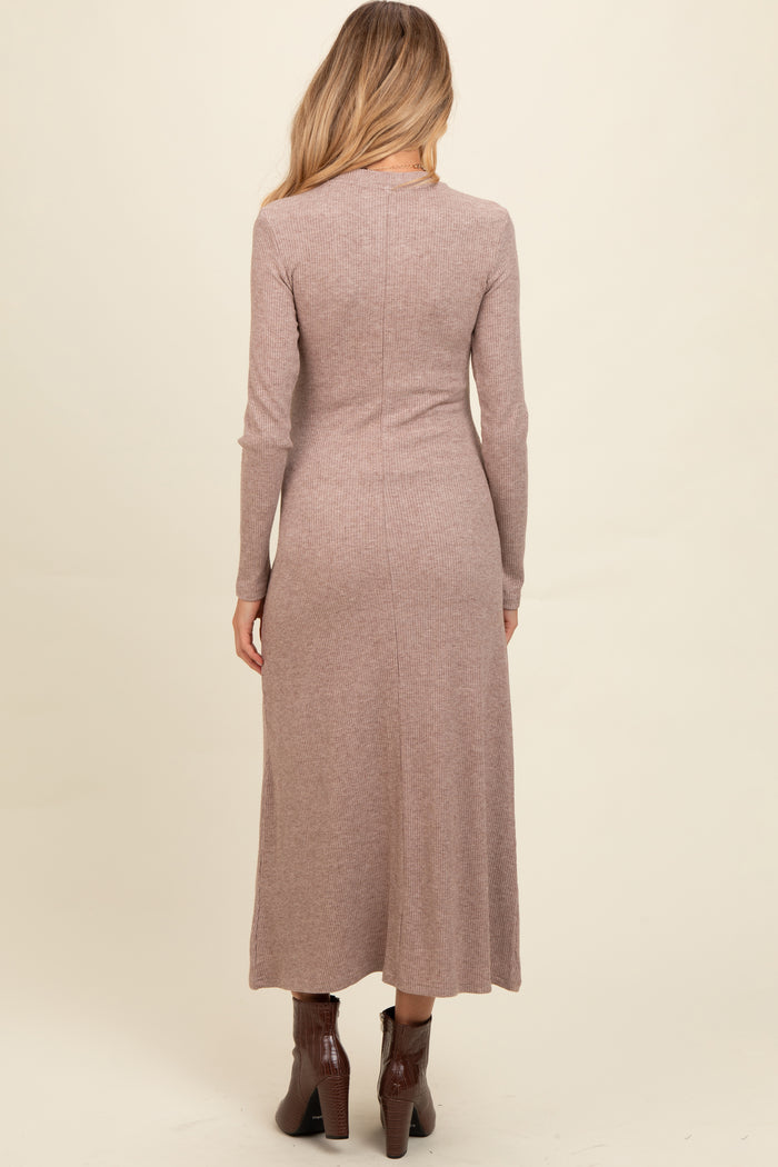 woman wearing a mauve long sleeve ribbed maternity dress, view from the back, with a fitted silhouette and ankle boots