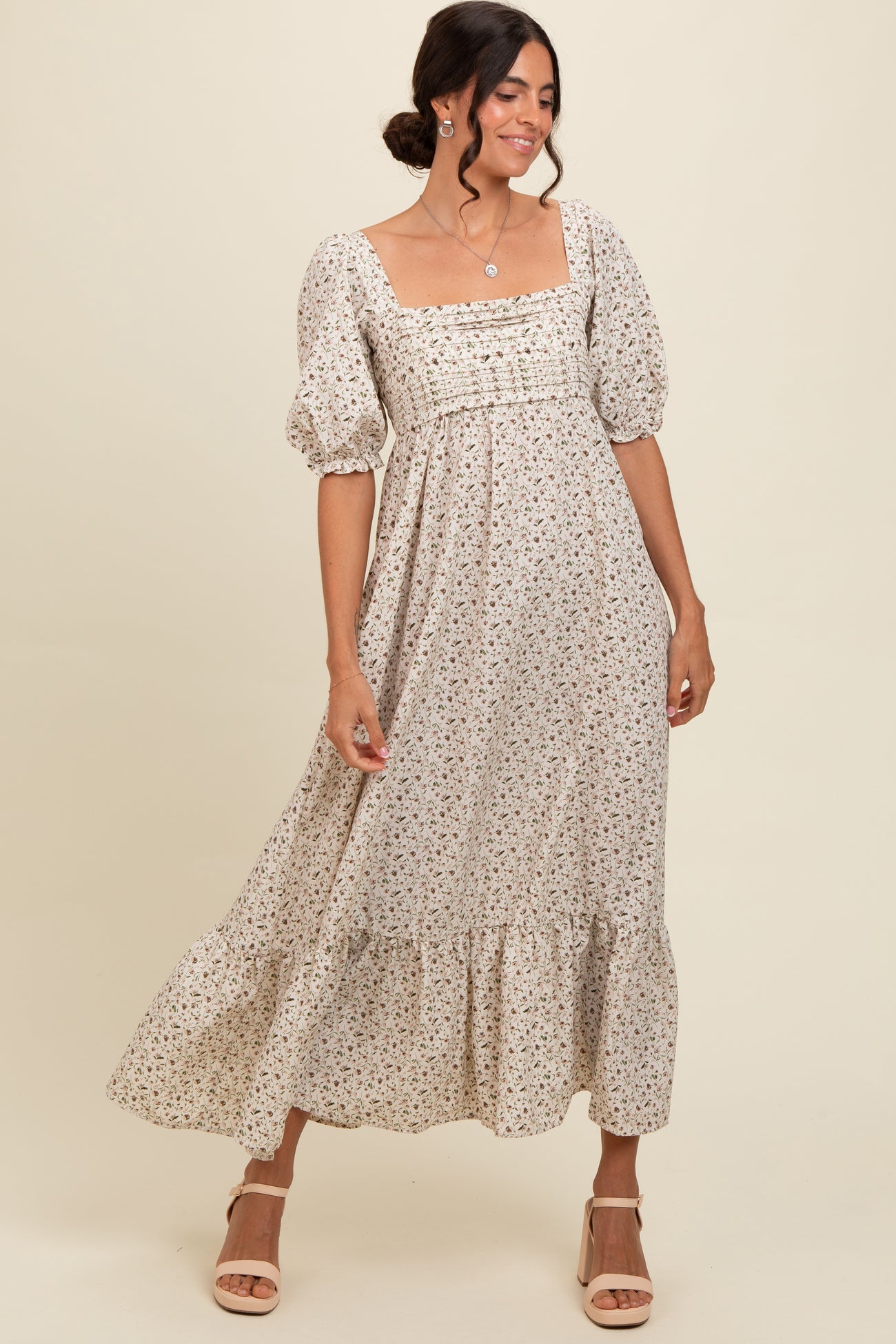 woman wearing a cream floral maxi dress with puff sleeves and a square neckline