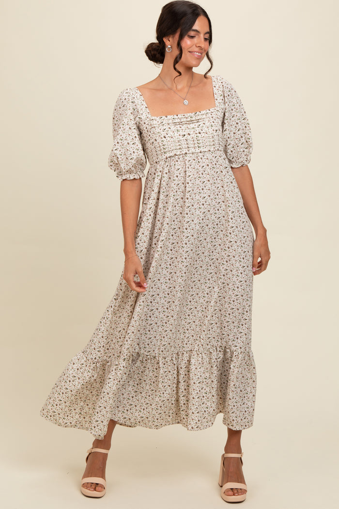 woman wearing a cream floral maxi dress with puff sleeves and a square neckline