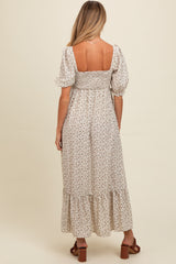 woman wearing a floral print maternity maxi dress with puff sleeves and a smocked bodice, showing a baby bump