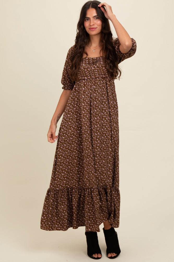 woman wearing a brown floral maxi dress with puff sleeves and a ruffled hem