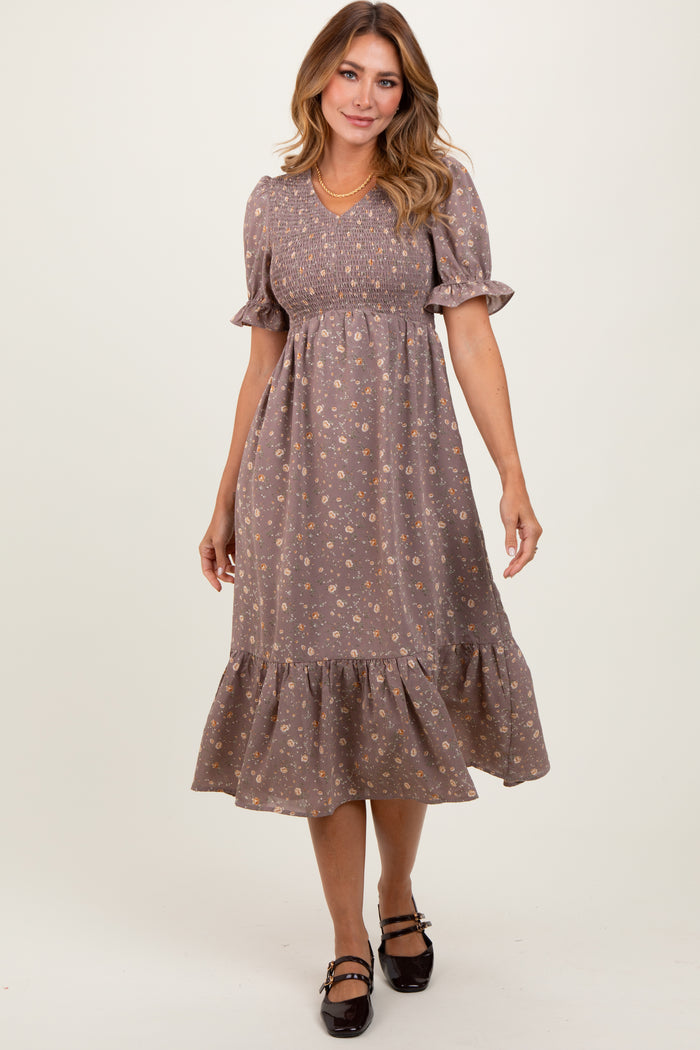 woman wearing a brown floral puff sleeve midi dress with a smocked bodice and a ruffled hem