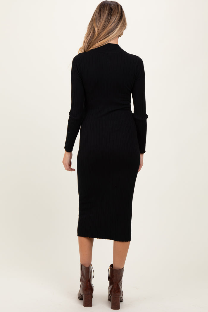 woman wearing a black ribbed maternity dress with long sleeves and a mid-length fit, showing a side view of her baby bump