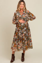 woman wearing a floral printed maternity dress with puffed sleeves and a tie neckline, highlighting her baby bump