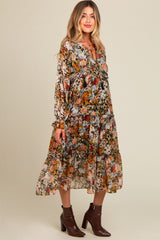 woman wearing a floral long sleeve maternity dress with ruffles and a tiered skirt