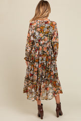 woman wearing a floral patterned maternity maxi dress with long sleeves and tiered ruffles from the back