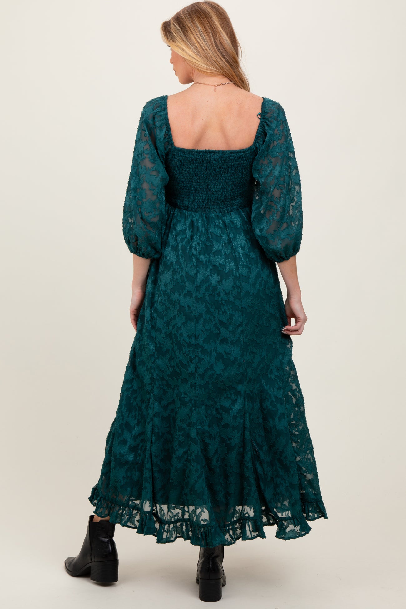 woman wearing a green floral maternity maxi dress with a smocked bodice and puff sleeves, showcasing a baby bump