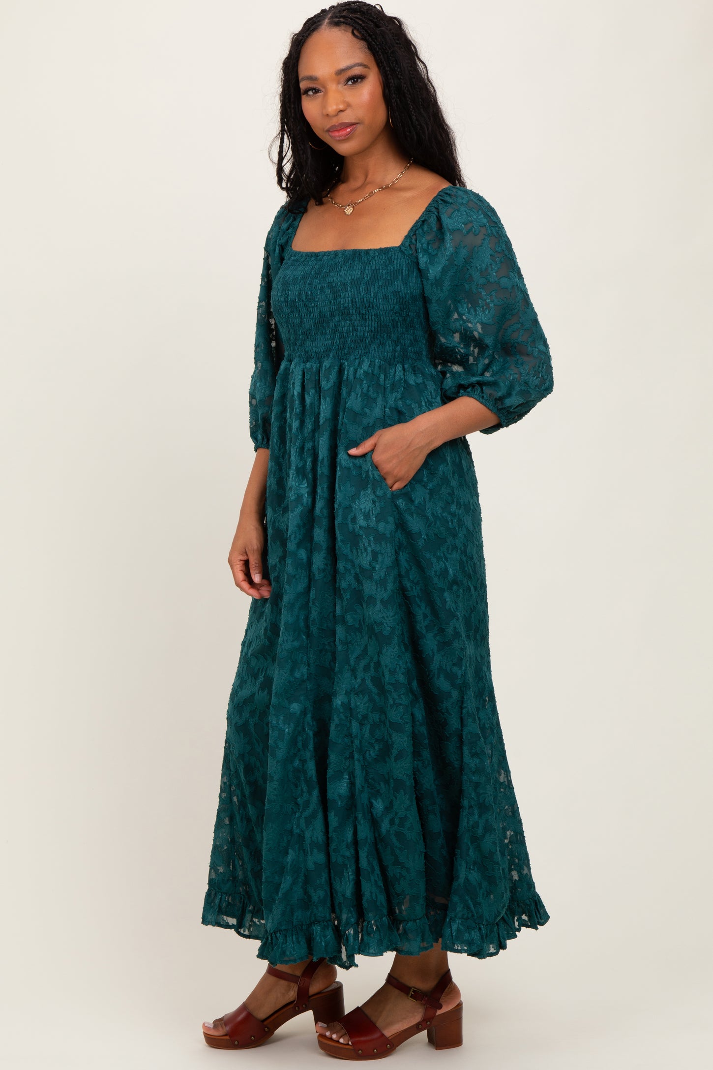 woman wearing a teal long sleeve maxi dress with square neckline and pockets