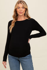 woman wearing a black long sleeve maternity top with side ruching and a visible baby bump
