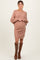 woman wearing a cable knit taupe maternity sweater dress with a visible baby bump and knee-high brown boots