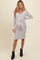 woman wearing a gray long sleeve maternity dress with a tie waist and a visible baby bump