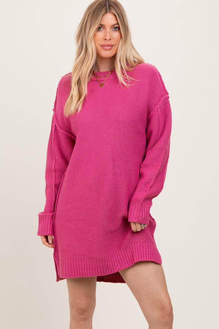 woman wearing a bright pink oversized sweater dress with long sleeves and side slits