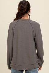 woman wearing a gray long sleeve sweatshirt with a relaxed fit and raglan sleeves, viewed from the back