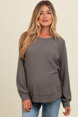 woman wearing a gray maternity sweatshirt with long sleeves and a relaxed fit, showing her baby bump