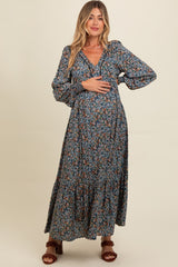 woman wearing a floral maternity maxi dress with long sleeves and a baby bump visible