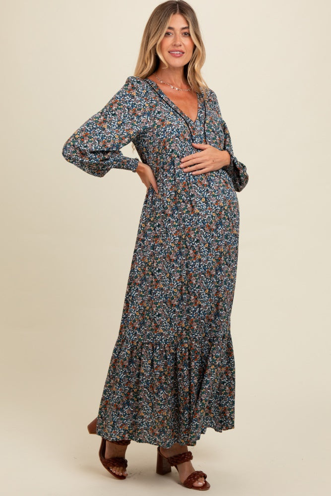 woman wearing a floral print maternity maxi dress with long sleeves and a baby bump visible
