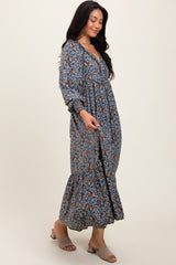 woman wearing a floral long sleeve maxi dress with a tiered skirt and a v-neckline, styled with slip-on sandals