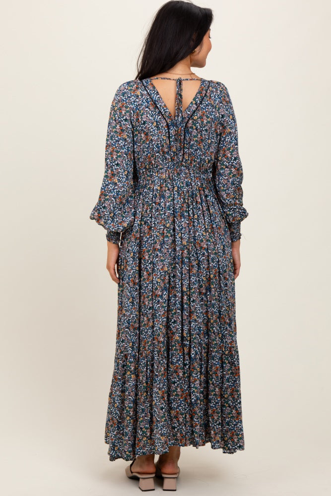 woman wearing a navy blue floral long sleeve maxi dress with a smocked waist and a keyhole back detail