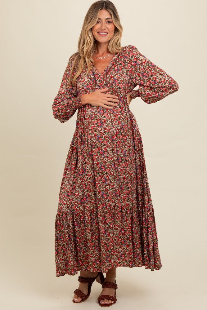 woman wearing a floral long sleeve maternity dress and holding her baby bump