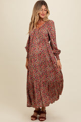 woman wearing a floral maxi maternity dress with long sleeves and a tiered skirt, showcasing her baby bump