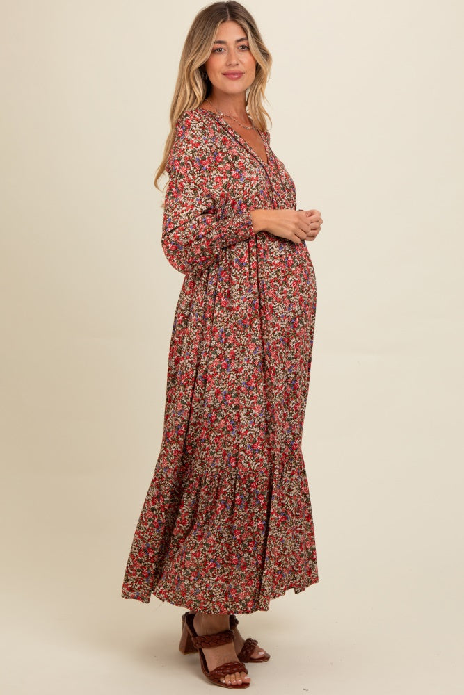 woman wearing a floral print maternity maxi dress with a v-neckline and long sleeves, showcasing her baby bump