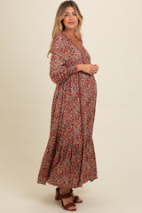 woman wearing a floral print maternity maxi dress with a v-neckline and long sleeves, showcasing her baby bump