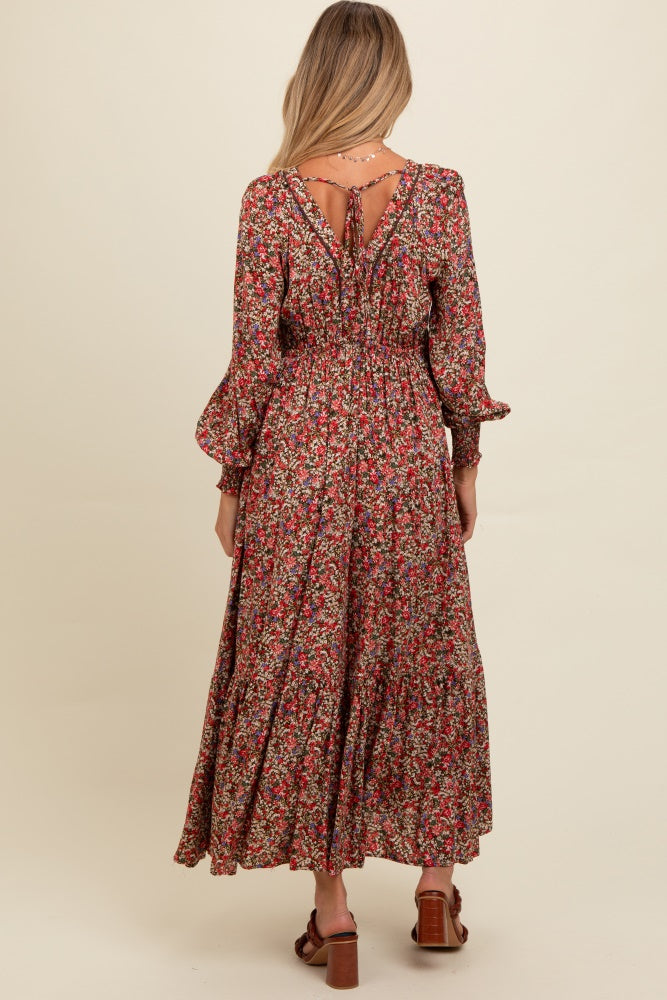 woman wearing a floral print maxi maternity dress with long sleeves and a tie detail at the back