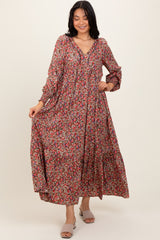 woman wearing a long floral maxi dress with a v-neckline and long sleeves, smiling at the camera