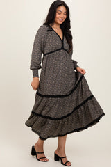 woman wearing a dark floral long sleeve maxi dress with a v-neck and ruffled hem, styled with black strappy heels