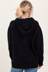 woman wearing a black oversized hoodie with a relaxed fit and a hood, shown from the back