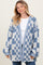 woman wearing a blue and white checked knit cardigan over a white top and jeans