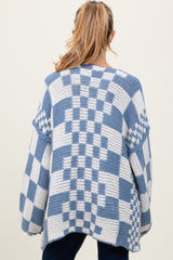woman wearing a blue and white checkered oversized maternity sweater, back view, with long sleeves and relaxed fit