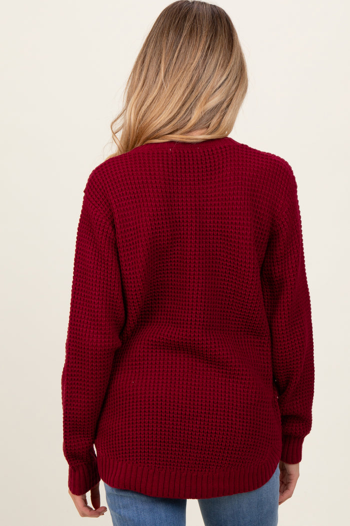 woman wearing a burgundy knit maternity sweater with a relaxed fit, shown from the back