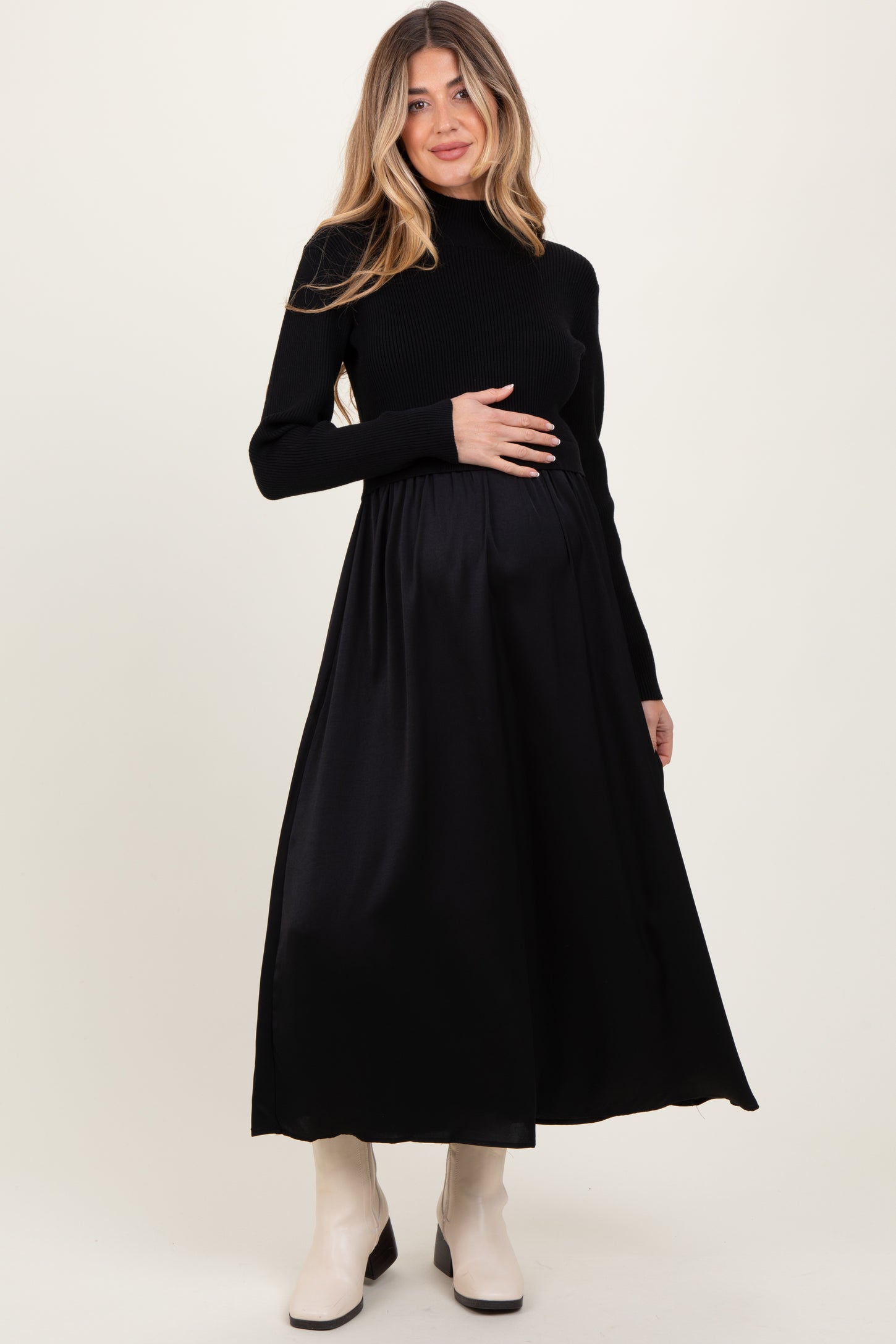 woman wearing a black maternity dress with long sleeves and a fitted bodice, showing her baby bump