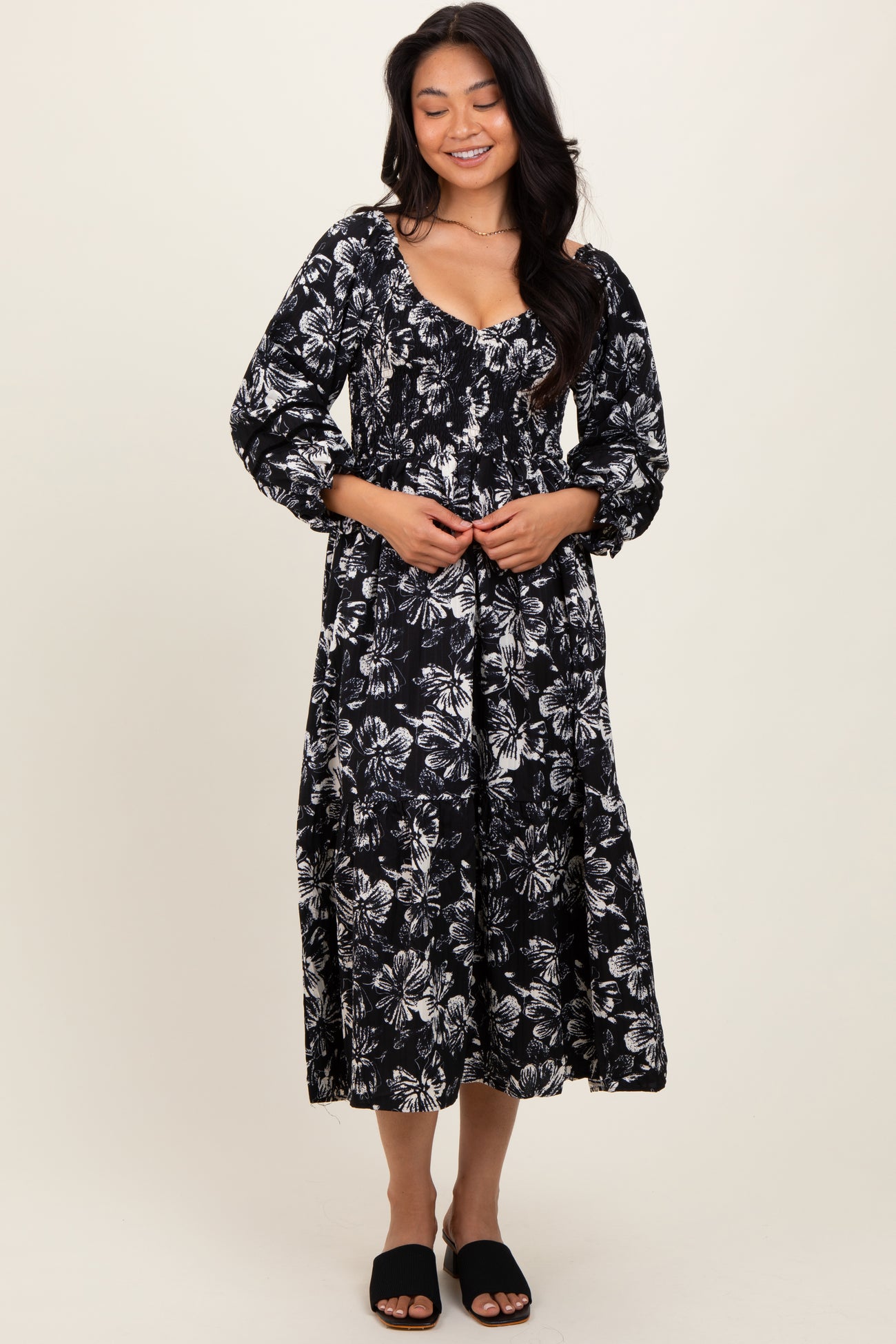 woman wearing a black and white floral print maxi dress with a scooped neckline and puffed sleeves