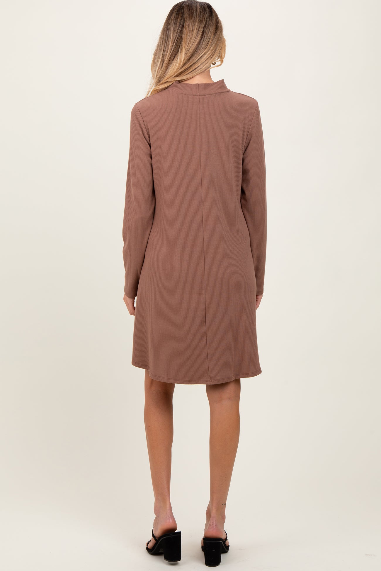 woman wearing a brown long sleeve maternity dress, shown from the back, with a relaxed fit and above-the-knee length
