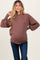 woman wearing a brown maternity sweater with balloon sleeves and a visible baby bump