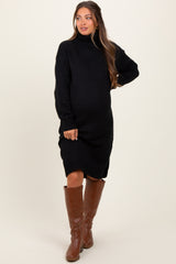 woman wearing a black knit maternity sweater dress with a high neck and long sleeves, showing her baby bump