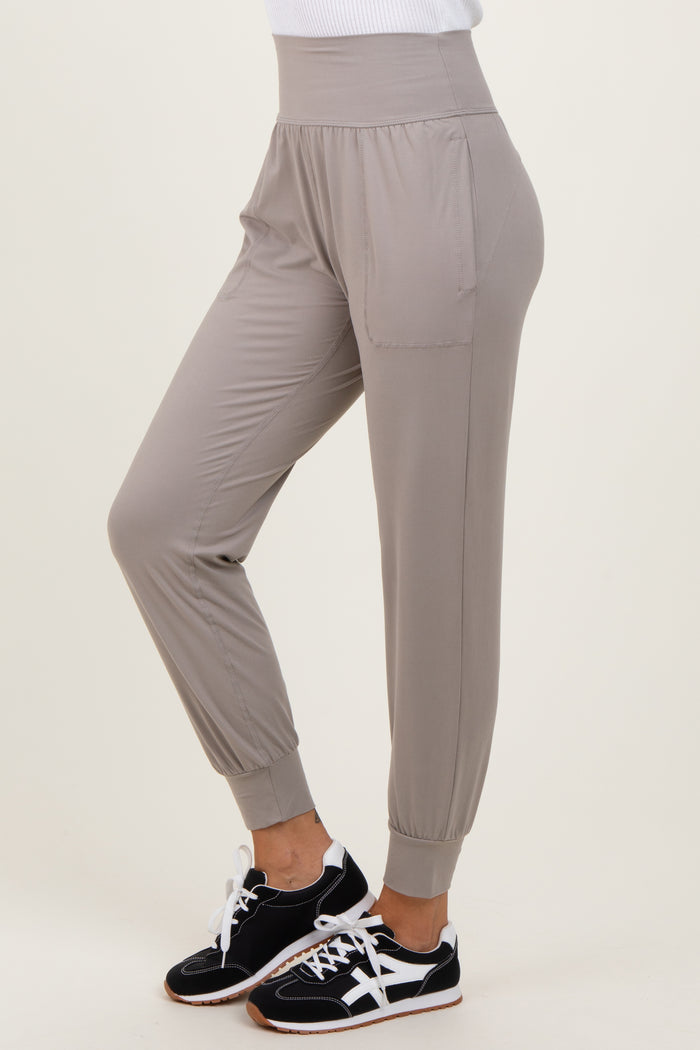 woman wearing light grey casual jogger pants with side pockets and elastic cuffs, paired with black sneakers