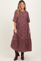 woman wearing a burgundy floral maternity maxi dress with short puff sleeves and tiered ruffles