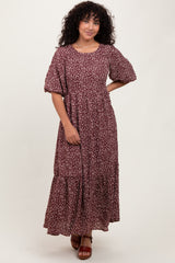 woman wearing a burgundy floral maxi dress with puff sleeves and a tiered skirt