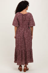woman wearing a burgundy floral maxi dress with short puff sleeves and a tiered skirt, viewed from the back