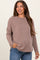 woman wearing a taupe ribbed maternity sweater with side pockets and a relaxed fit
