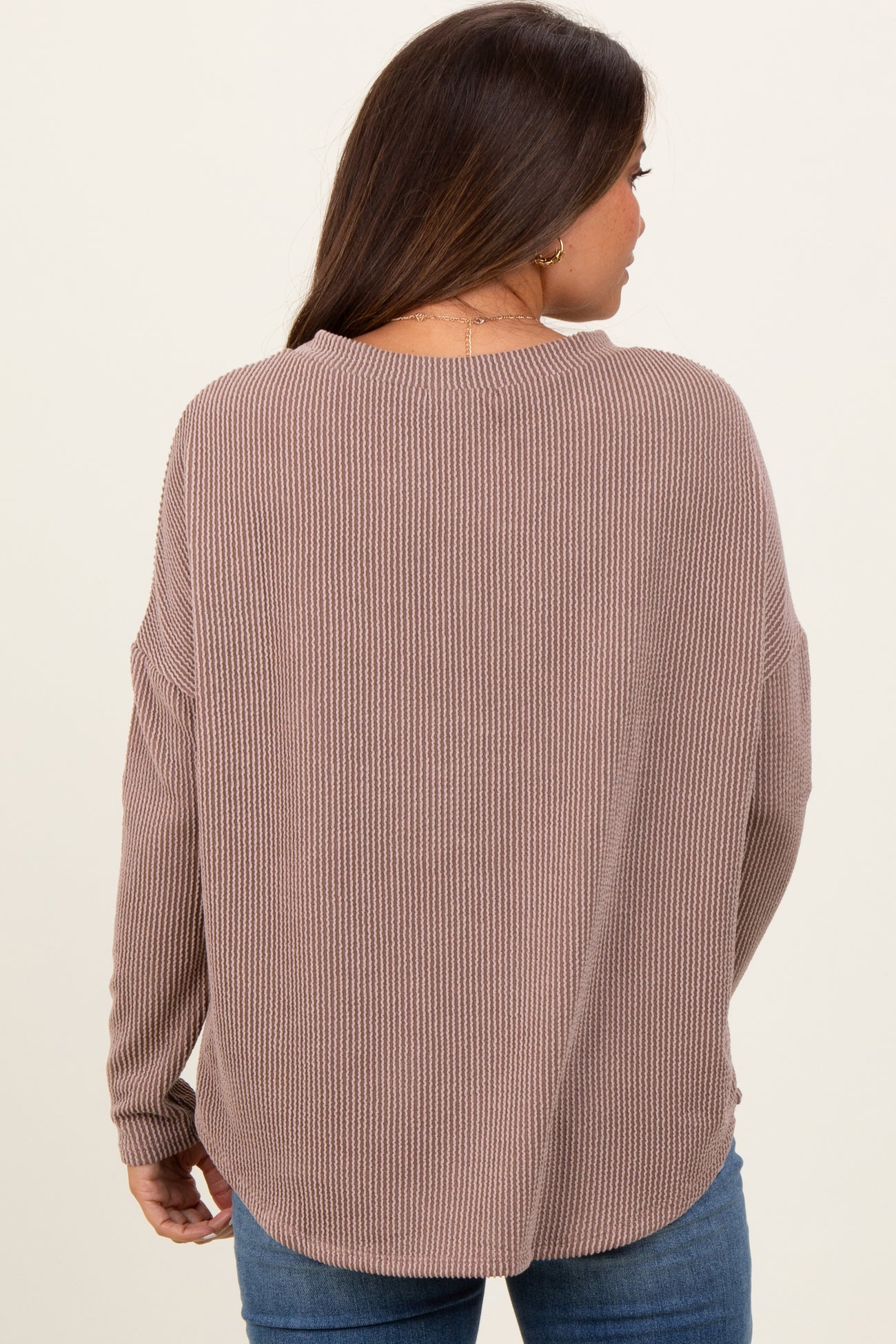 woman wearing a mauve ribbed maternity sweater with a relaxed fit