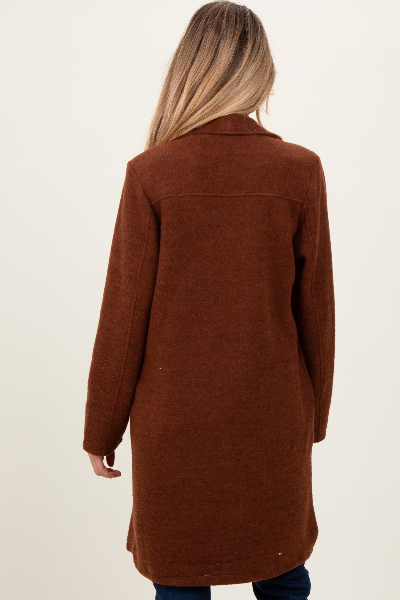 woman wearing a cozy brown maternity coat, styled with a relaxed fit and long sleeves, viewed from the back